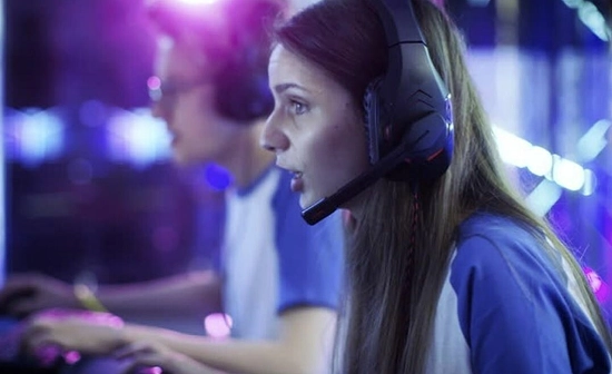 vrouwelijke gamer met headset geconcentreerd tijdens spel